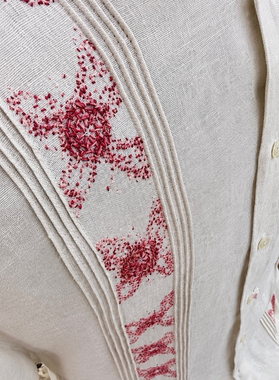 Herlinda Flores beige linen guayabera shirt with intricate red floral embroidery and vertical pleat detailing.