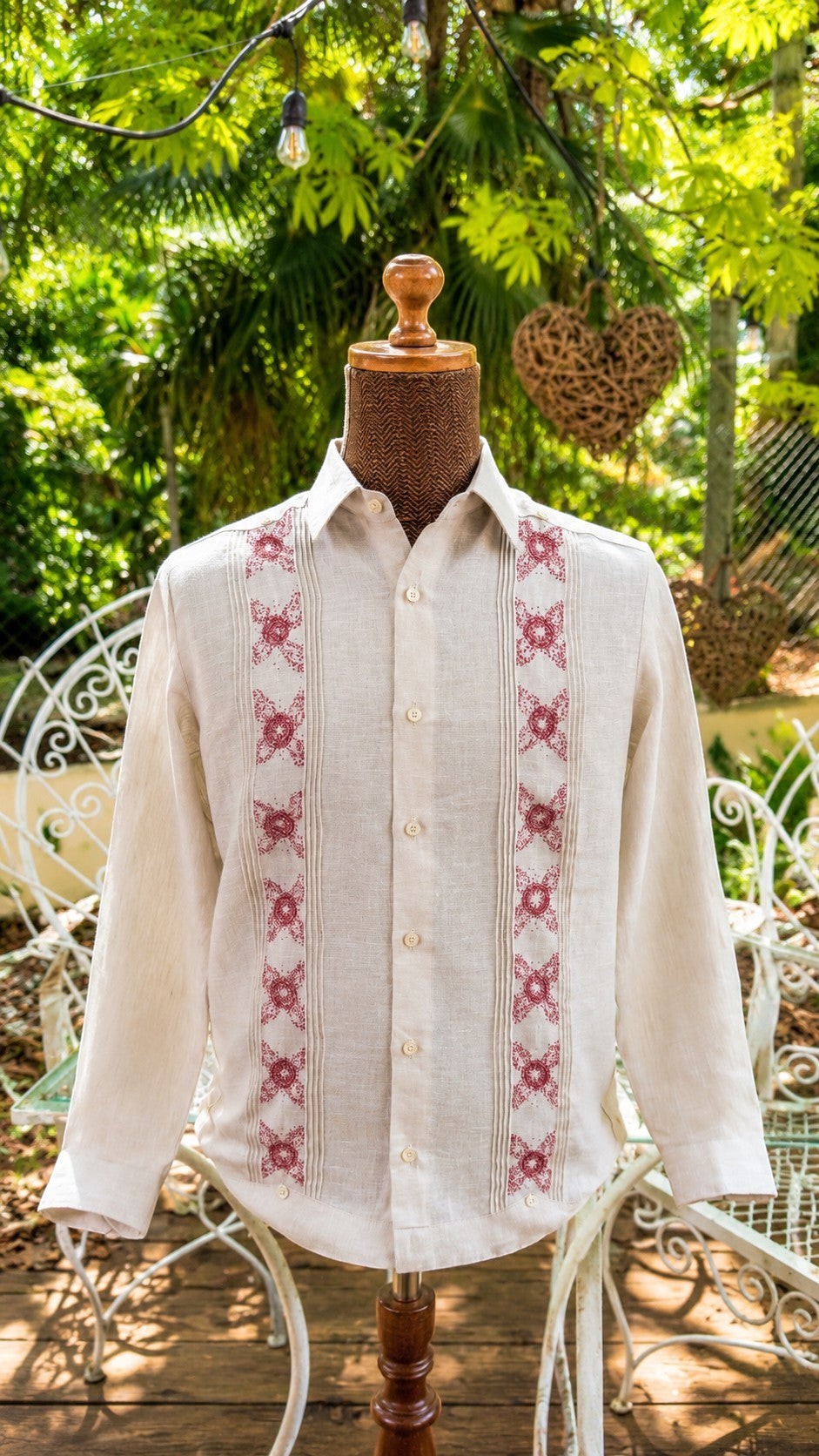 Herlinda Flores beige linen guayabera shirt with vertical pleats and intricate red floral embroidery on a mannequin.